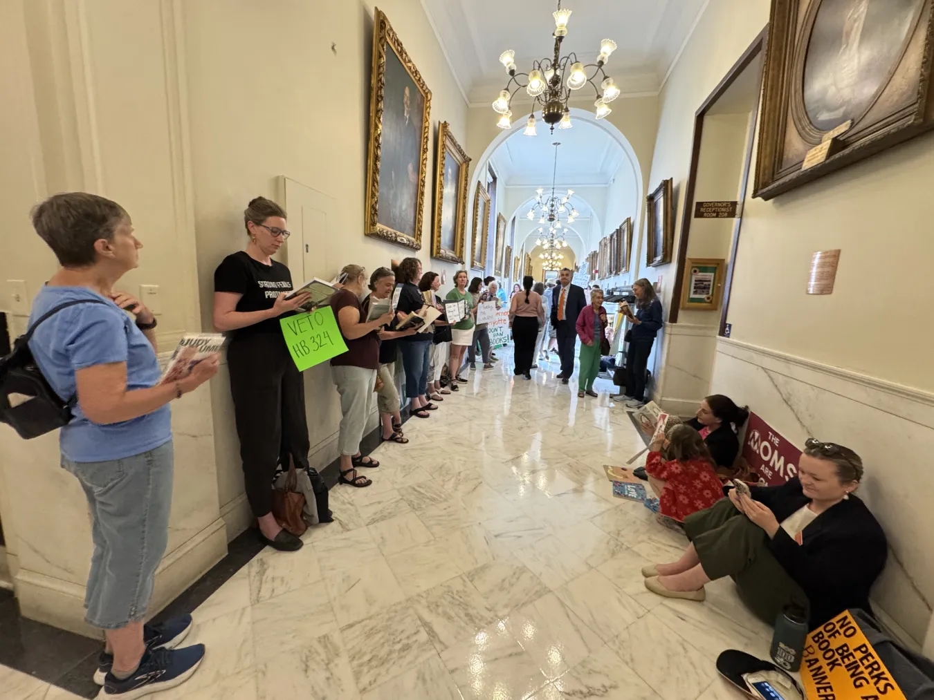 A group of advocates reads in the hallway outside of Governor Ayotte's office to protest a book ban bill.
