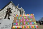 An image of a sign that reads "Education is a Right, Not a Luxury" with the State House and Christa McAuliffe statue in the background.