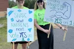 Middleton EA members hold signs outside of the polls encouraging voters to support their contract.
