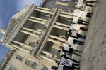 Advocates gather with protest signs outside of the New Hampshire State House.