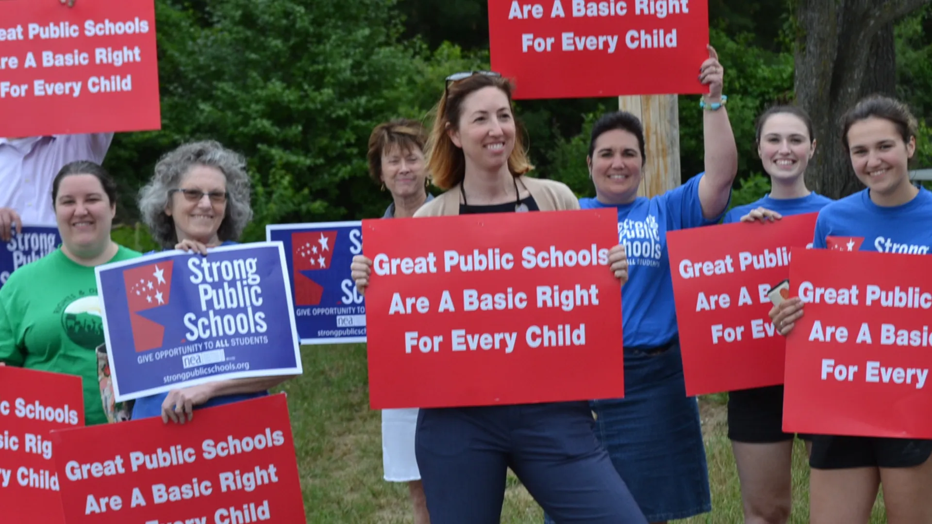 member demonstration with signs that read, "Great public school are a basic human right for every child"