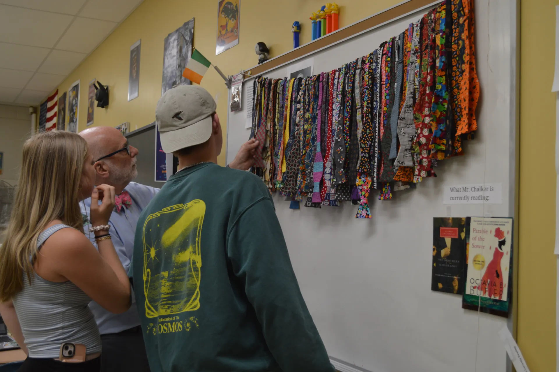 English teacher Skip Chalker views a variety of his handmade bow ties with students in his high school classroom.