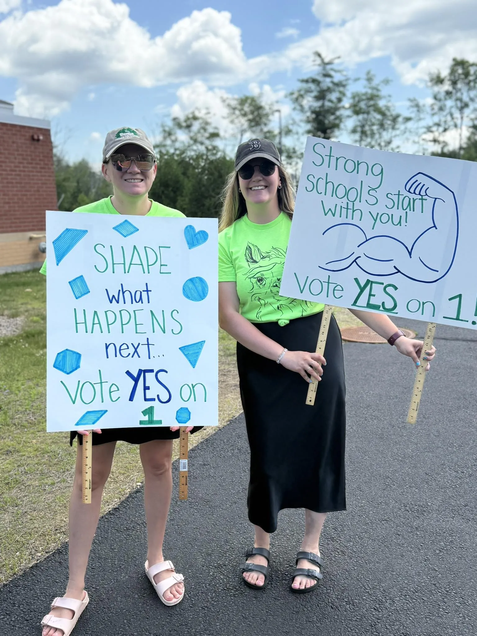 Middleton EA members hold signs outside of the polls encouraging voters to support their contract.