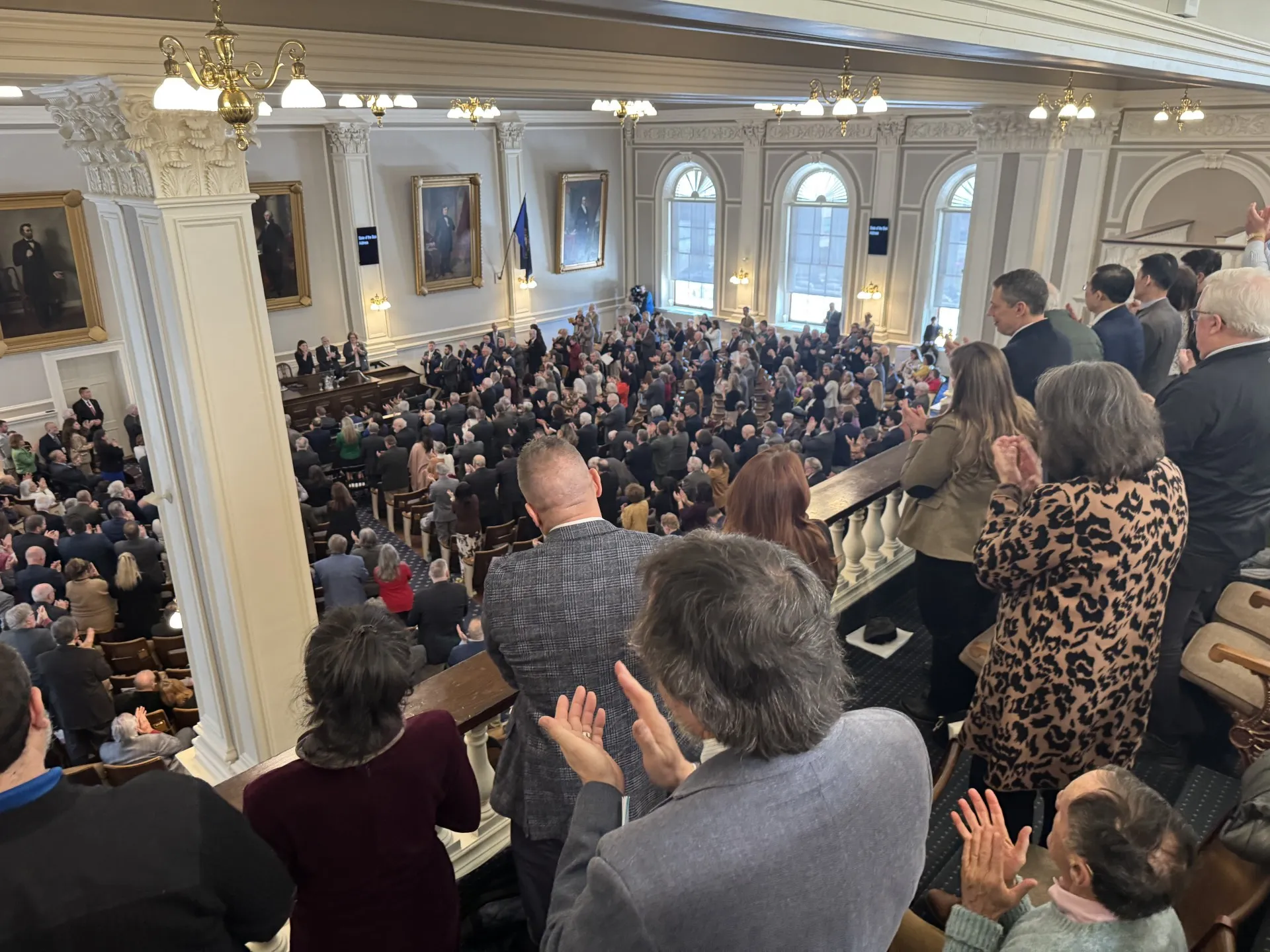 Audience members rise in applause during Governor Ayotte's 2026 State of the State Address after she thanked teachers and support staff for all they do for New Hampshire students.