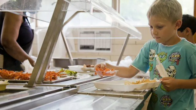 A student picking up school lunch in the cafeteria.